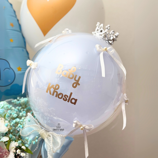 Luxury baby boy birth announcement hamper with personalized balloons, fresh flowers, and chocolates in a white gift box.