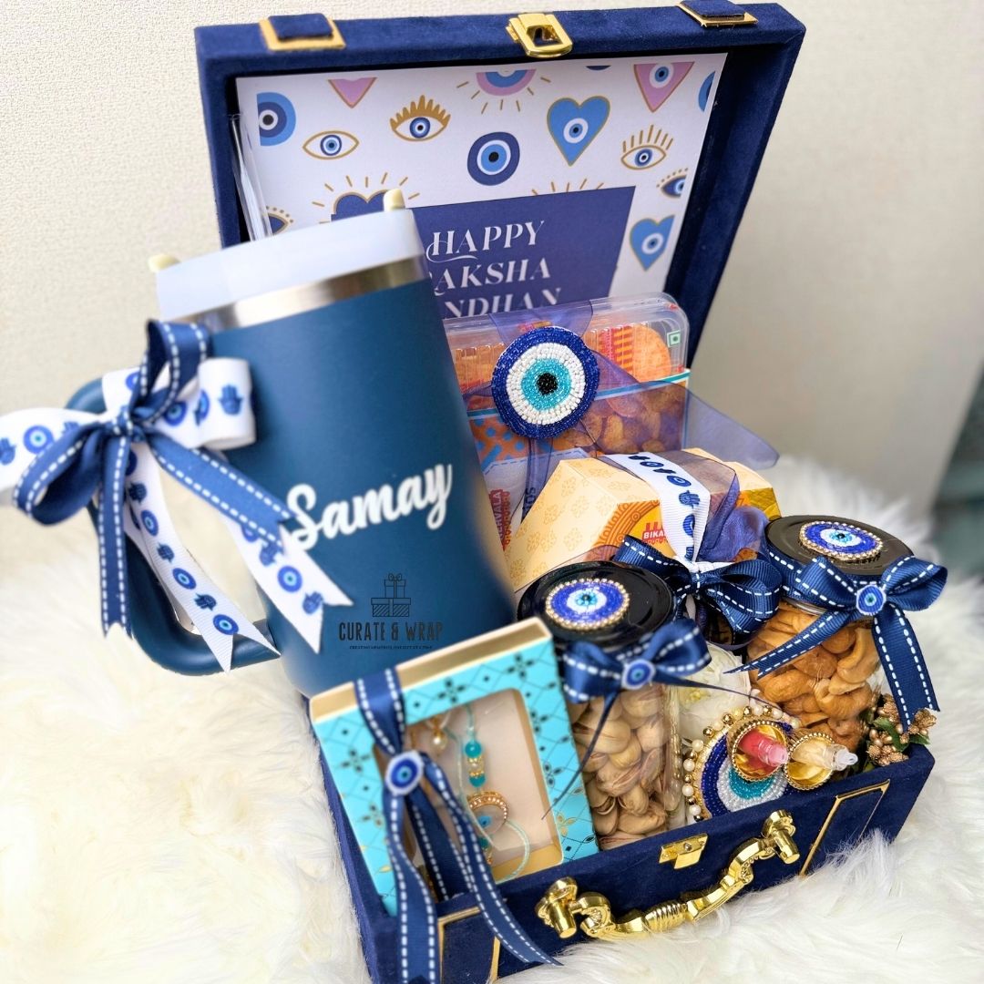 Gift basket with a blue thermos, snacks, and decorative items on a white surface.