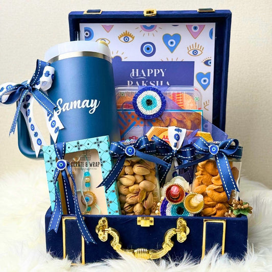 Gift set with a blue mug, snacks, and decorative items in a decorative box.