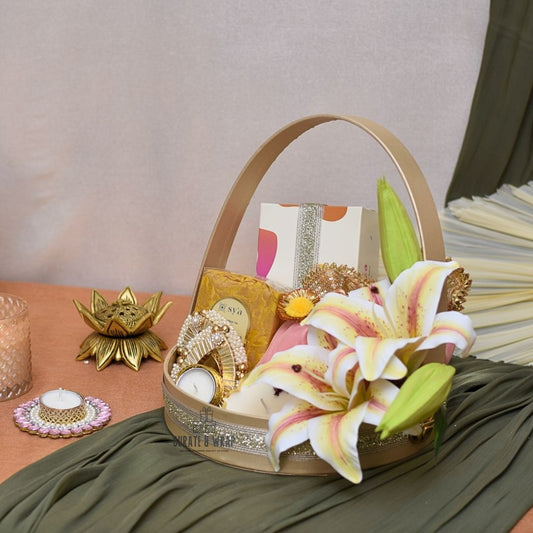 Decorative basket with flowers, candles, and decorative items on a table.