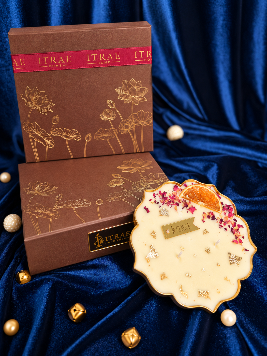 Itrae Home Lotus Metal Urli scented candle in gold, decorated with floral petals and orange slice, with premium brown gift box