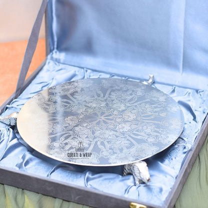 Decorative round tray with intricate patterns in a blue box