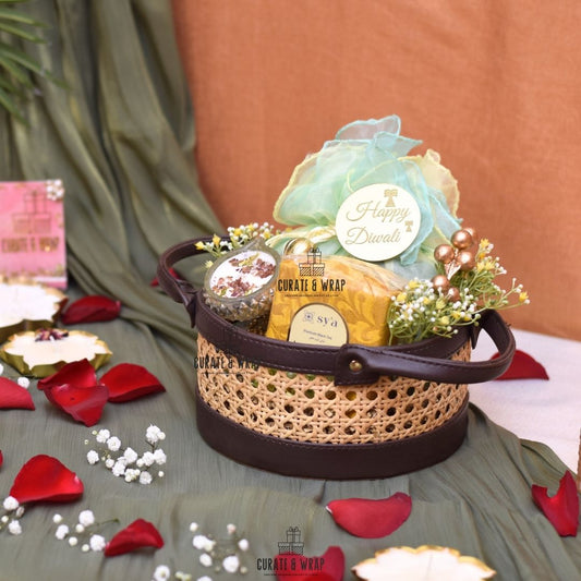 Decorative gift basket with 'Happy Diwali' message on a table with rose petals