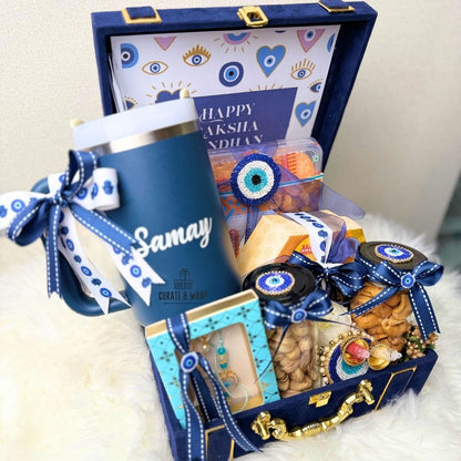 Gift basket with a blue thermos, snacks, and decorative items on a white surface.