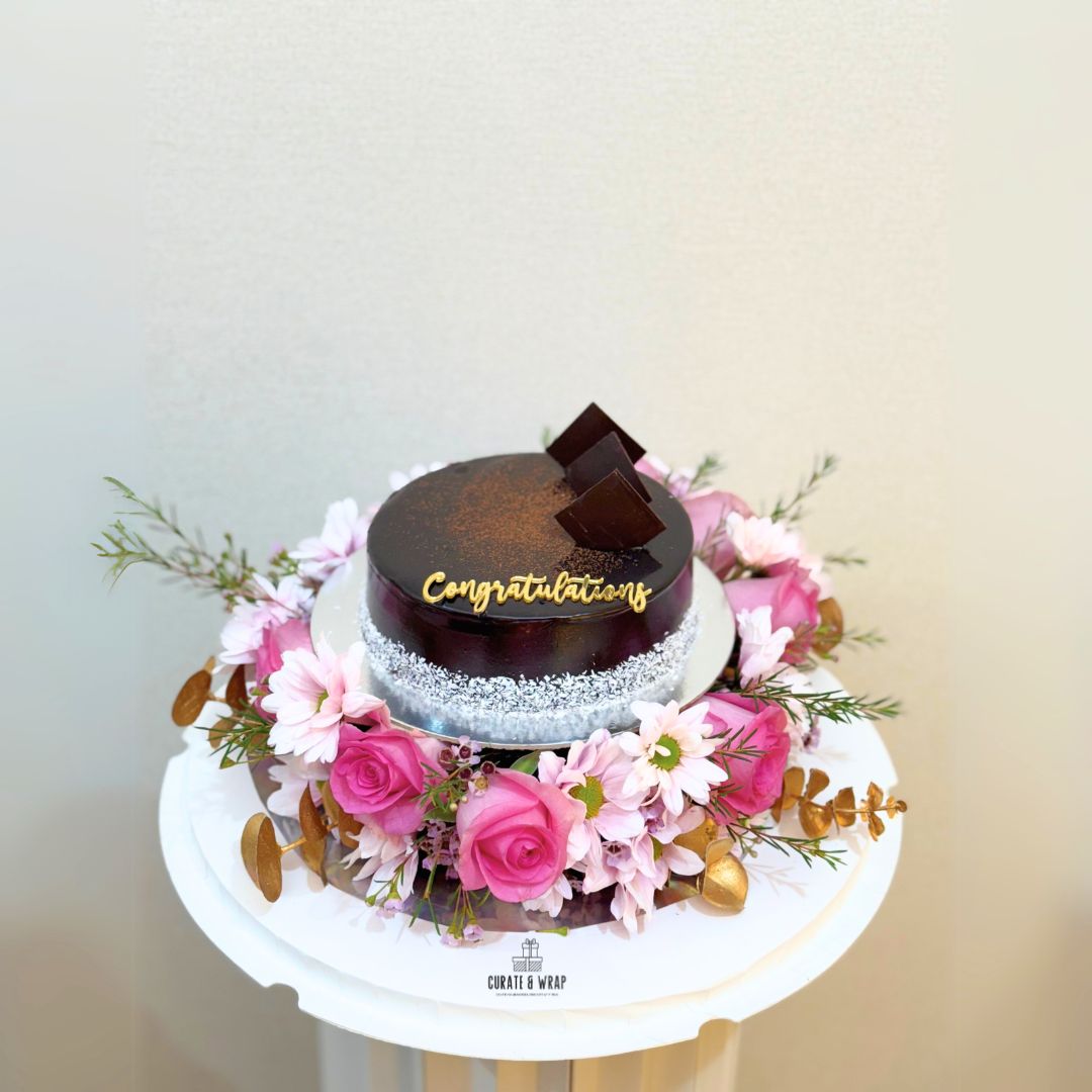 Luxury gift hamper with half kg cake and fresh pink flowers in a round box by Curate and Wrap, ideal for all occasions. Mothers day, birthday, Anniversary 