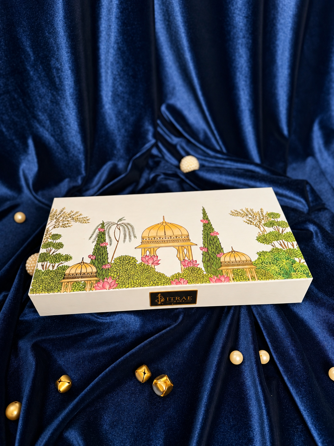 Itrae Home Dhanya Candle Box featuring two 5.5-inch gold metal Urli scented candles, candle snuffer and matchbox in an ivory satin-lined gift box