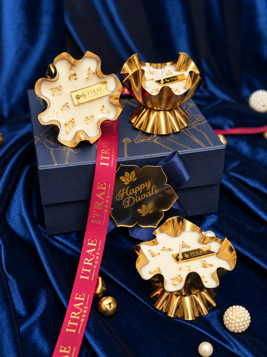 Itrae Home set of three gold metal Ruffle Urli scented candles with decorative gold accents, displayed with a premium navy blue Diwali gift box