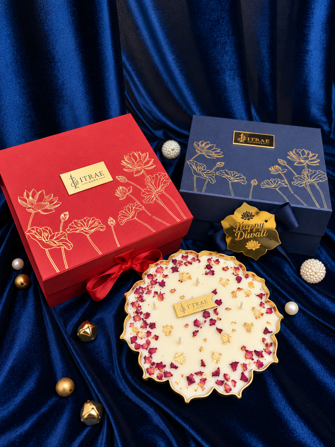 Itrae Home Ananta Box featuring a 6.5-inch gold metal Urli scented candle decorated with rose petals, alongside premium red and navy blue Diwali gift boxes